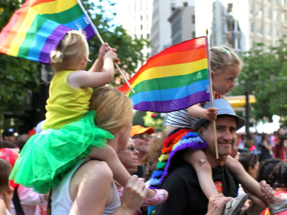 A family from our congregation waving rainbow flags at the Pride Parade